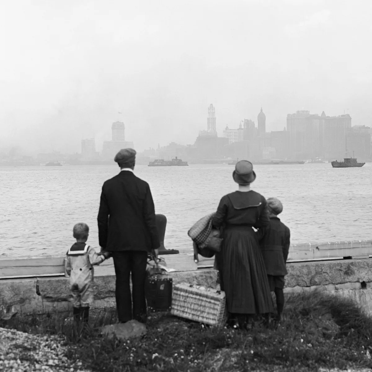 (Original Caption) 8/13/1925-New York, NY: Above is a striking photo showing a little immigrant family on the dock at Ellis Island, N.Y., just having passed the rigid examination for entry into the "land of promise" looking hopefully at New York's skyline while awaiting the government ferry to carry them on to the land of the free.